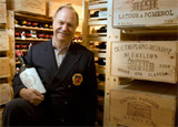Eric Vogt, eProvenance’s founder, stands in a wine cellar with a bottle of Bordeaux